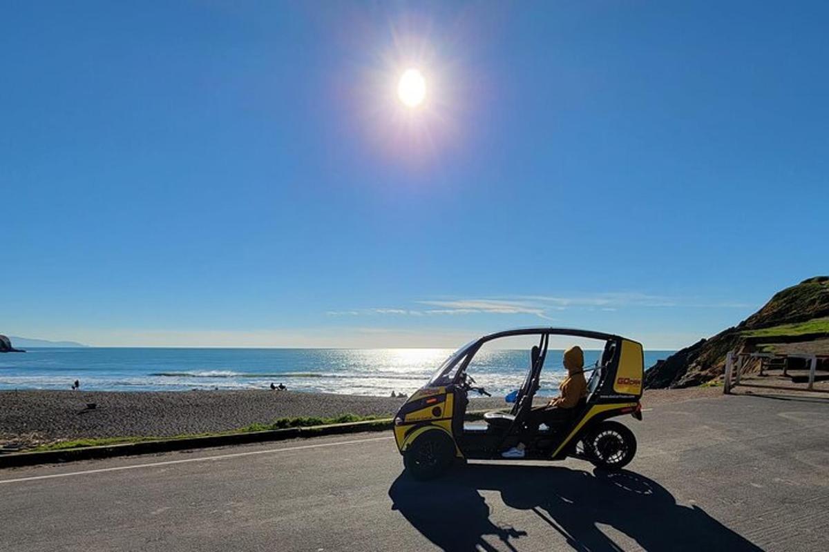 una persona alla guida di un golf cart su una strada vicino alla spiaggia