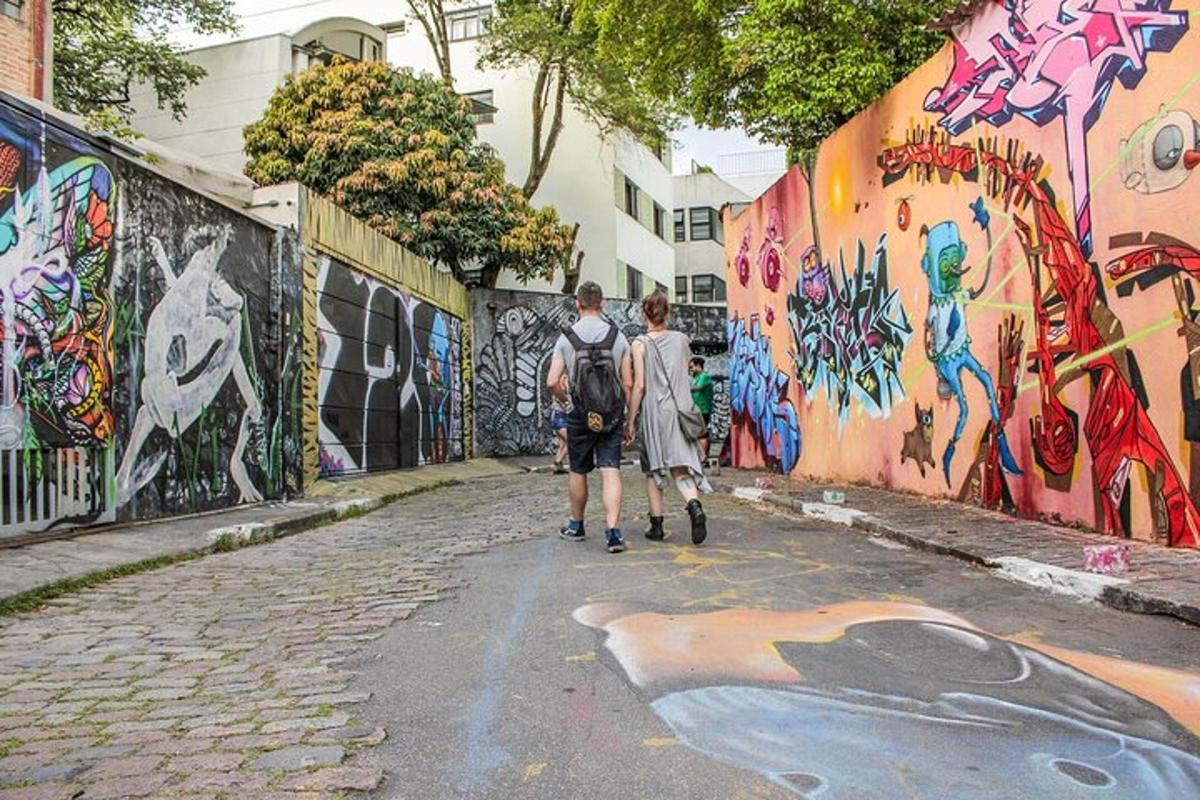dva človeka hodita po ulici z grafiti