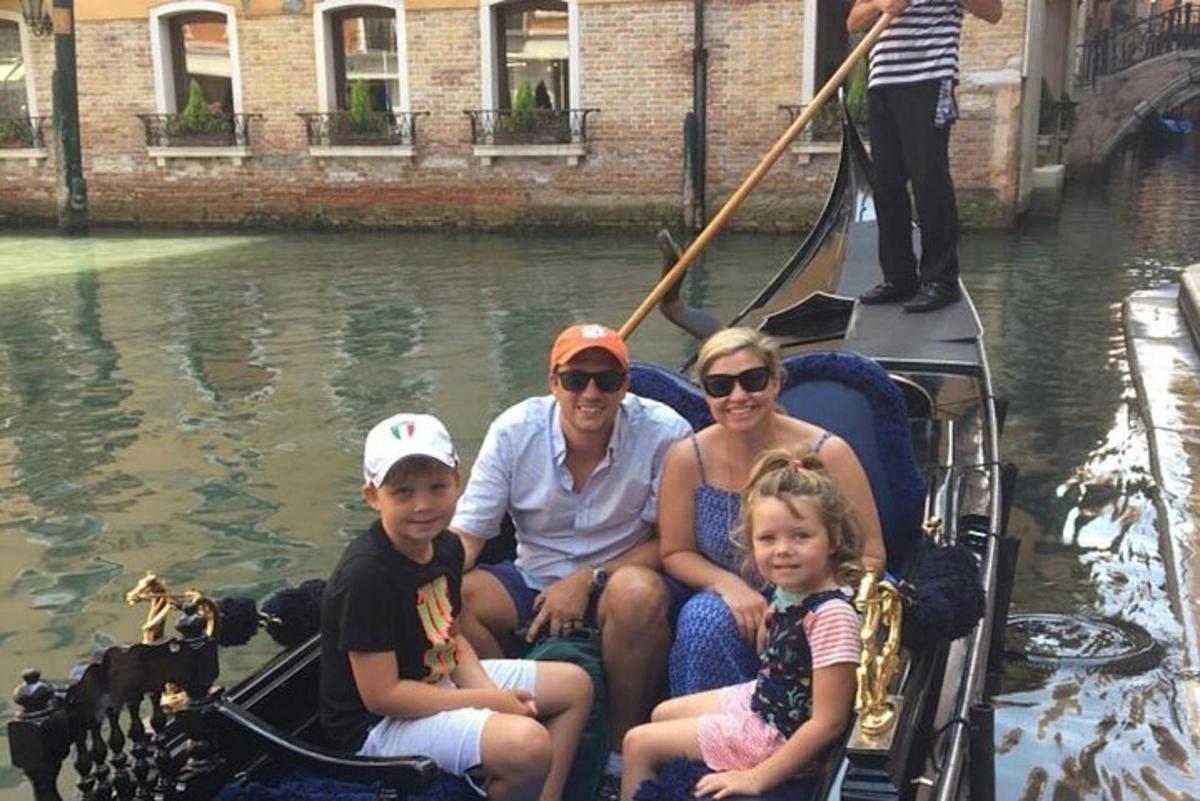 una famiglia seduta in una gondola su un canale