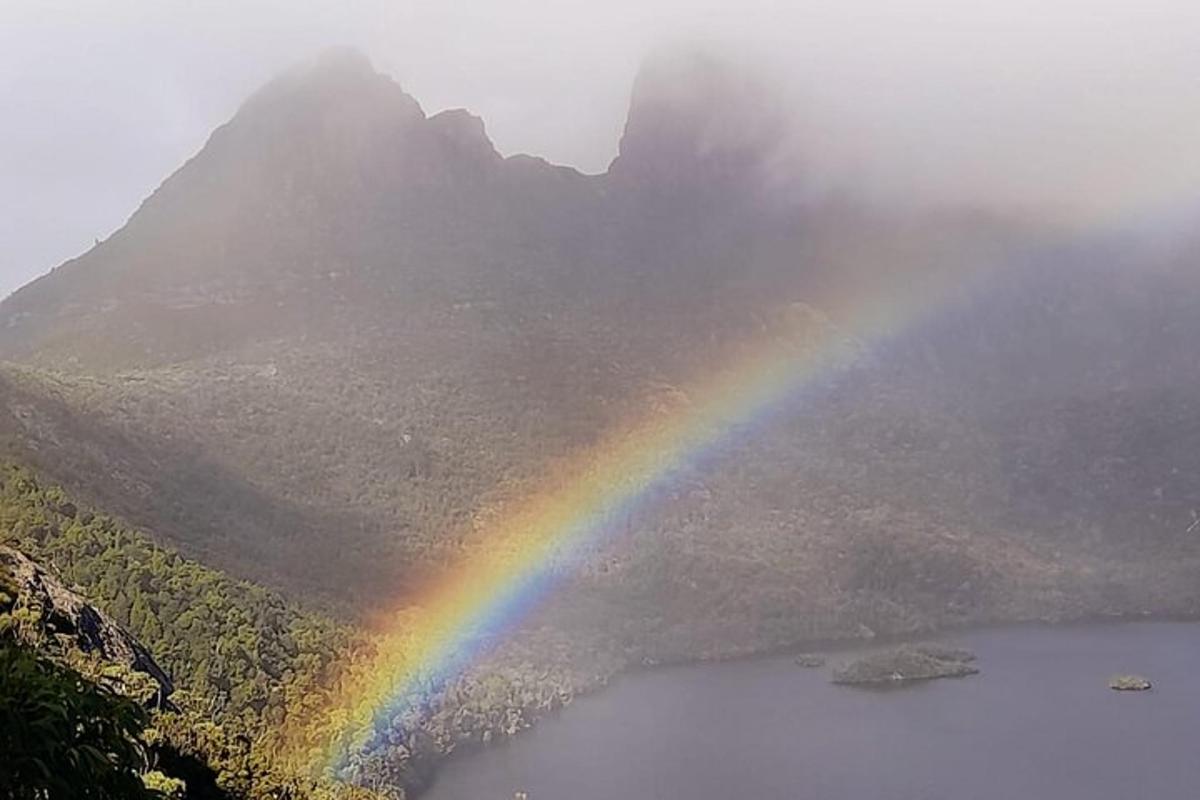 un arcobaleno sopra un lago con una montagna