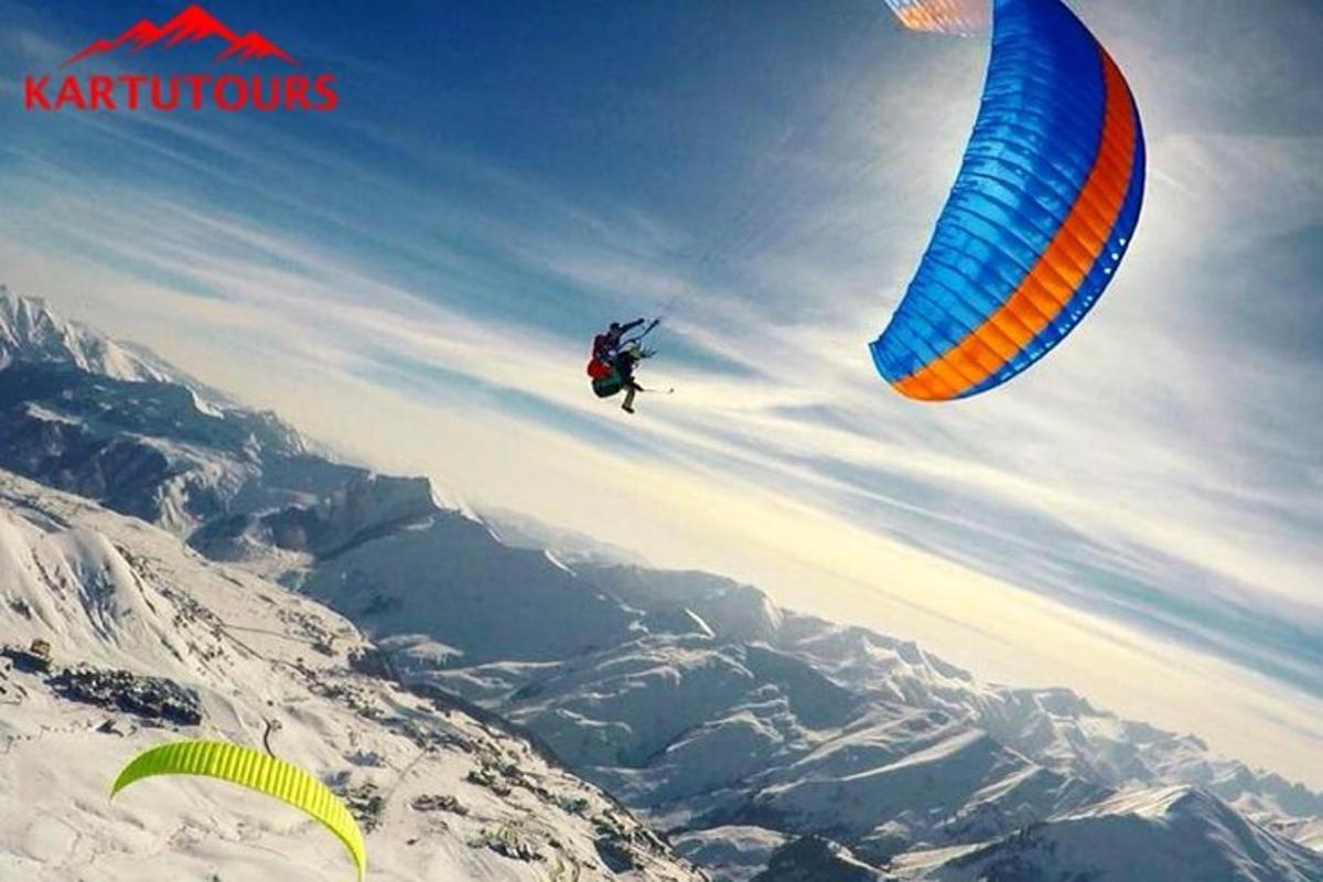 людина, яка запускає повітряного змія над горою