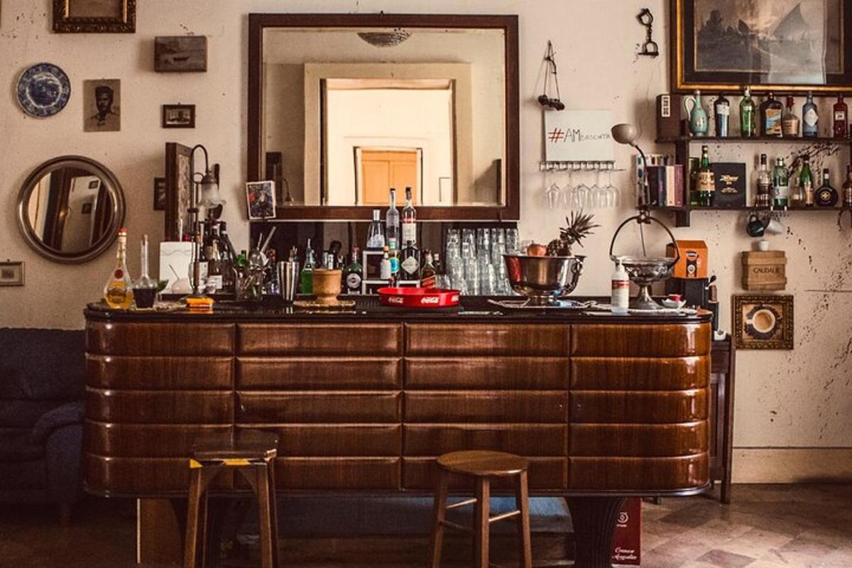 a bar in a room with two stools and a mirror