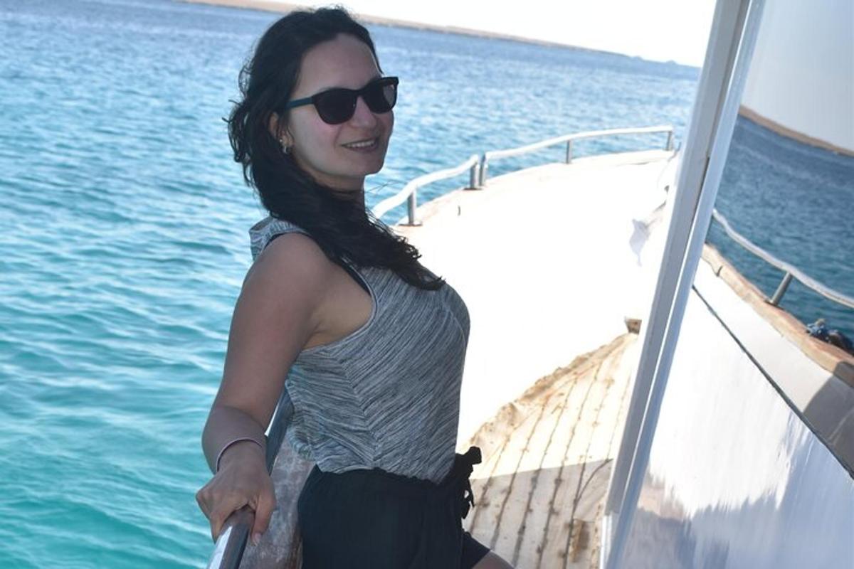 žena se slunečními brýlemi stojící na boku lodi