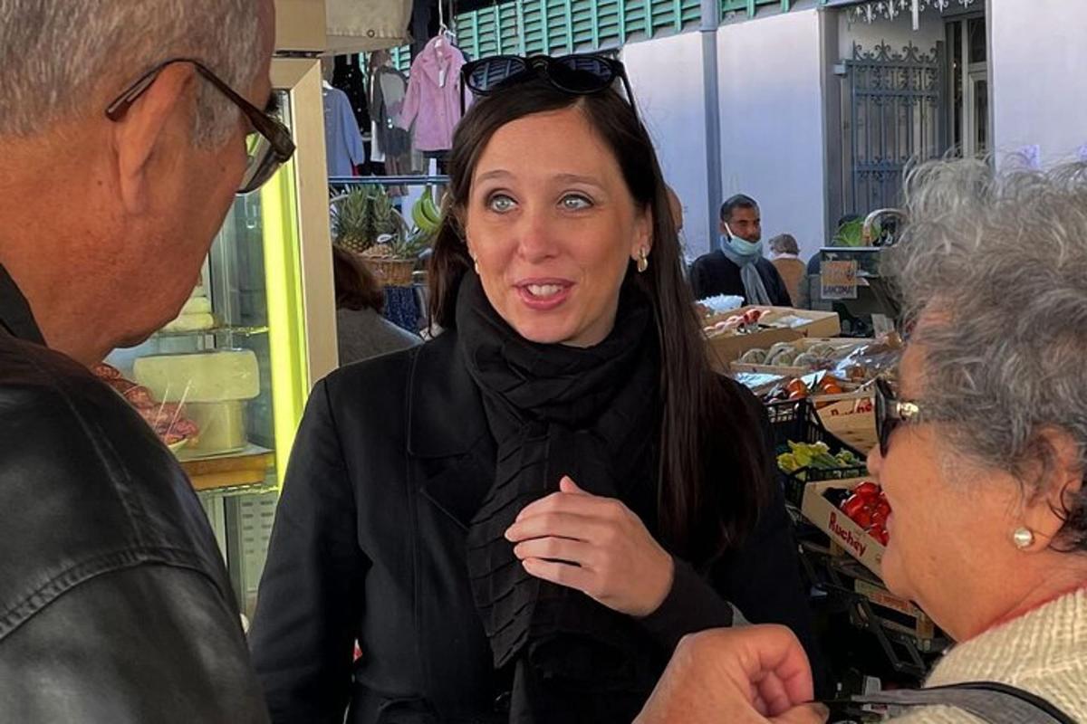 امرأة تقف في متجر تتحدث إلى رجل