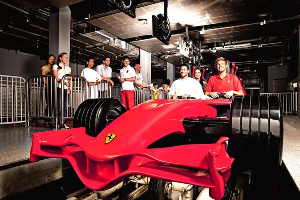 a group of people standing around a red race car