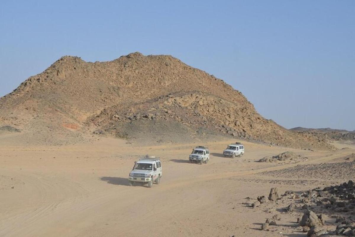 tre auto che percorrono una strada sterrata nel deserto