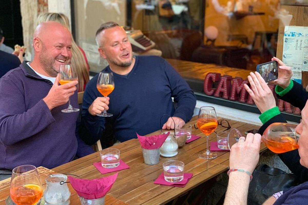 um grupo de pessoas sentadas ao redor de uma mesa com taças de vinho