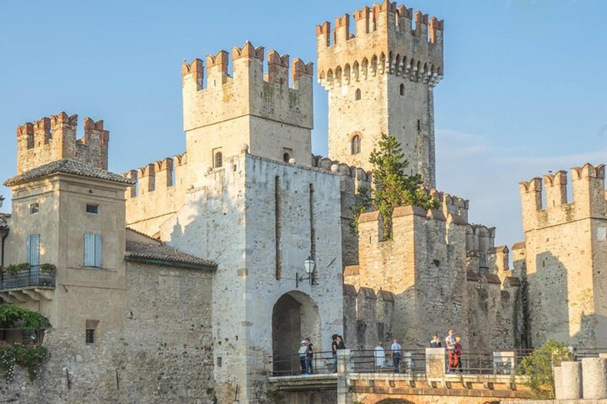 un castello con due torri e persone in piedi su un ponte