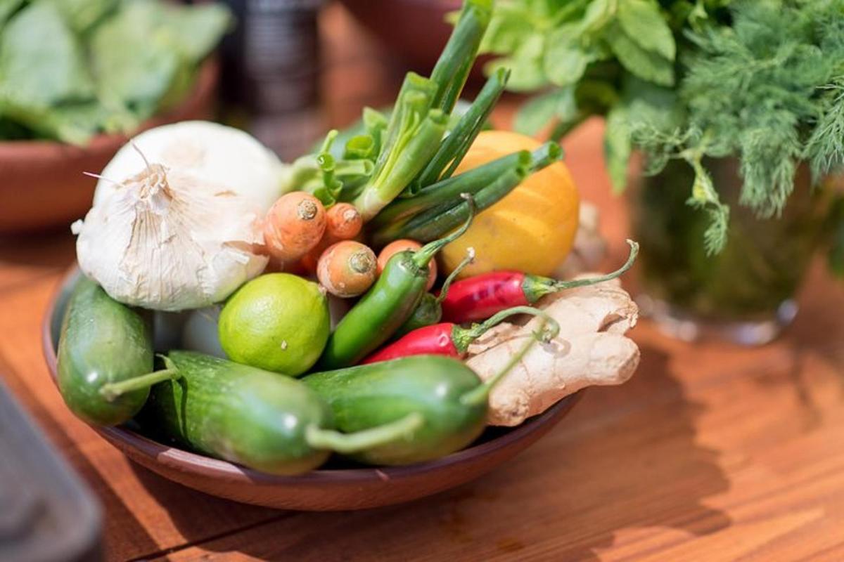 uma tigela de vegetais sobre uma mesa de madeira