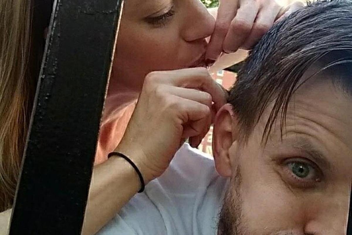 a woman is kissing a mans head