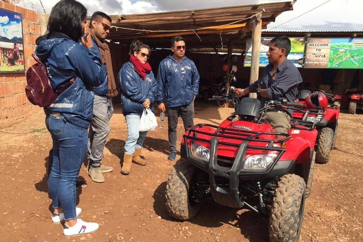 sekumpulan orang berdiri di sekeliling atv merah