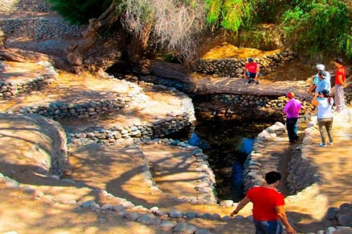 a group of people walking on rocks near a river