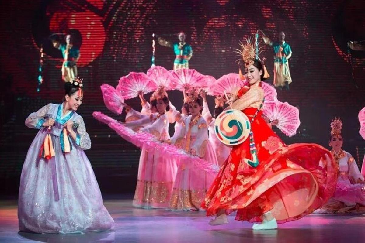 a group of women dancing on a stage with umbrellas