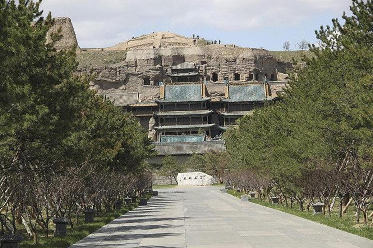 a large building with a mountain in the background