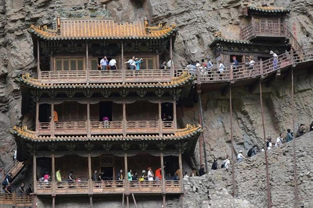 a building on a cliff with people on the balconies