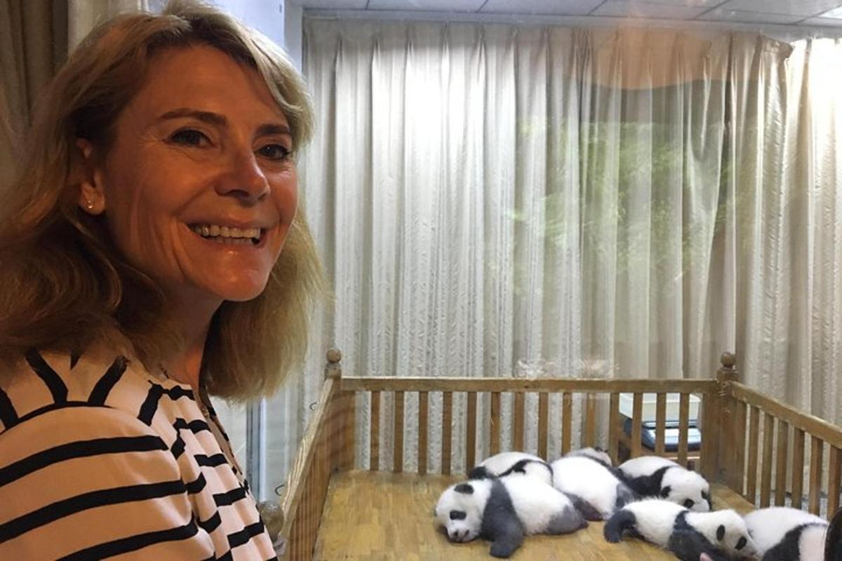 a woman standing next to a crib with stuffed pandas