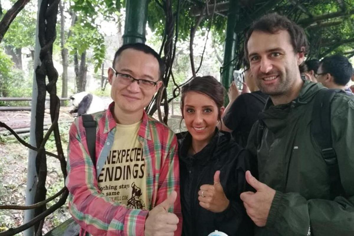 two men and a woman giving thumbs up at a zoo