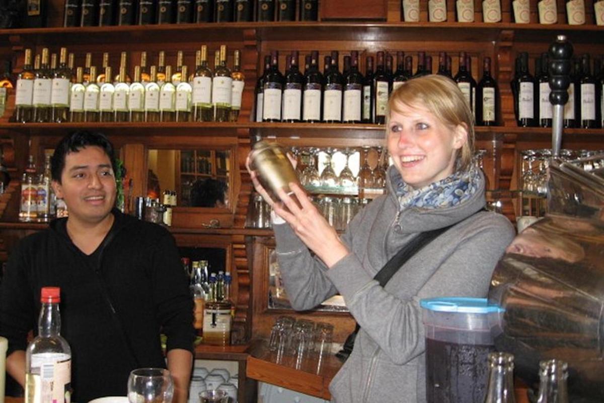 een vrouw die aan een bar staat met een fles wijn in haar handen