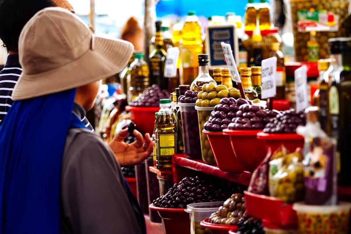 un bărbat care fotografiază o tarabă cu fructe într-o piață