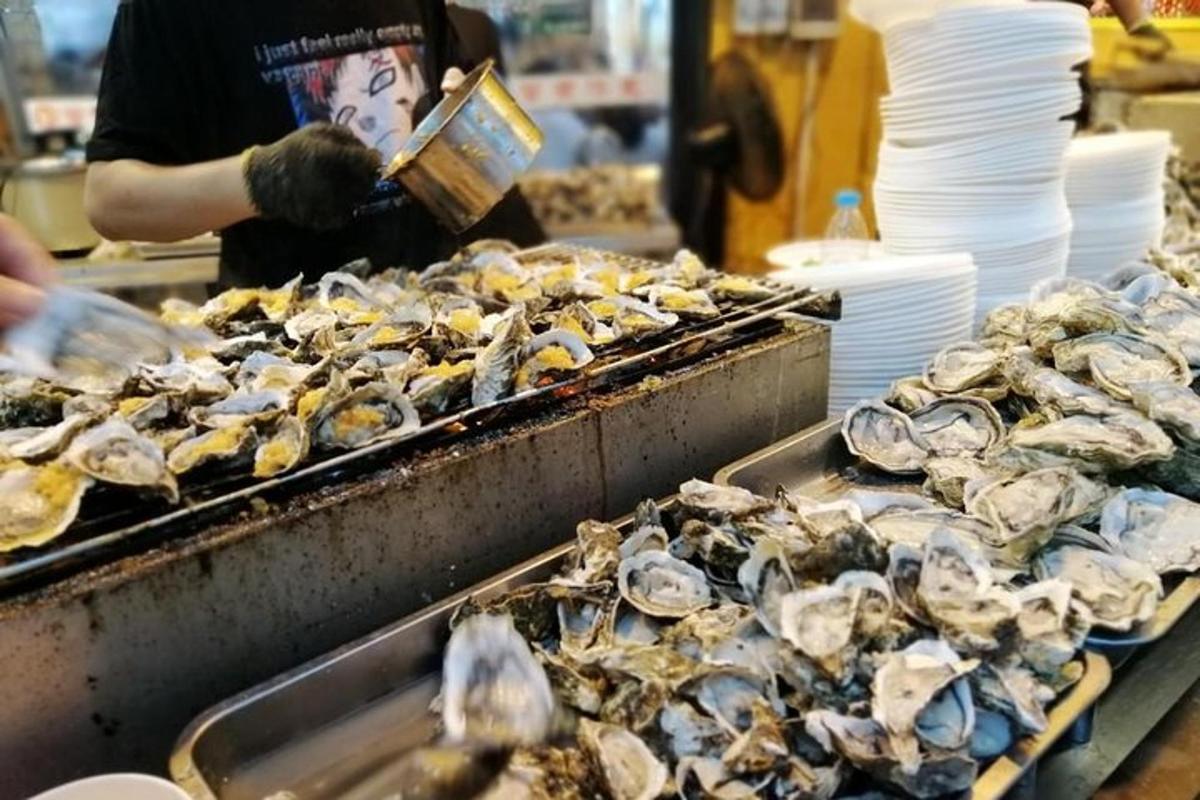 a person is preparing oysters in a market