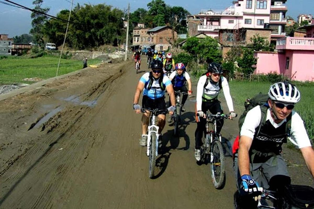 grupa ludzi jadących na rowerach po drodze gruntowej