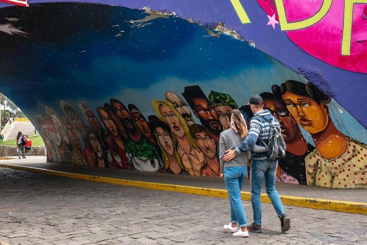 dva lidé stojící před zdí s nástěnnou malbou