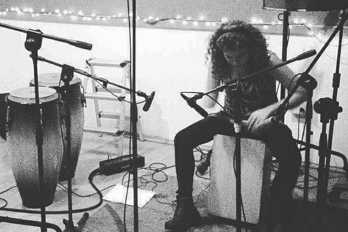 a woman sitting on a drum set in a room