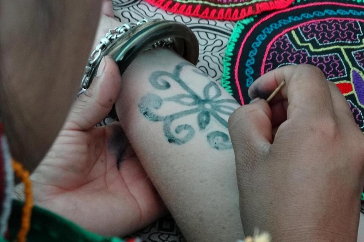 una persona con un tatuaggio di un fiore sul braccio