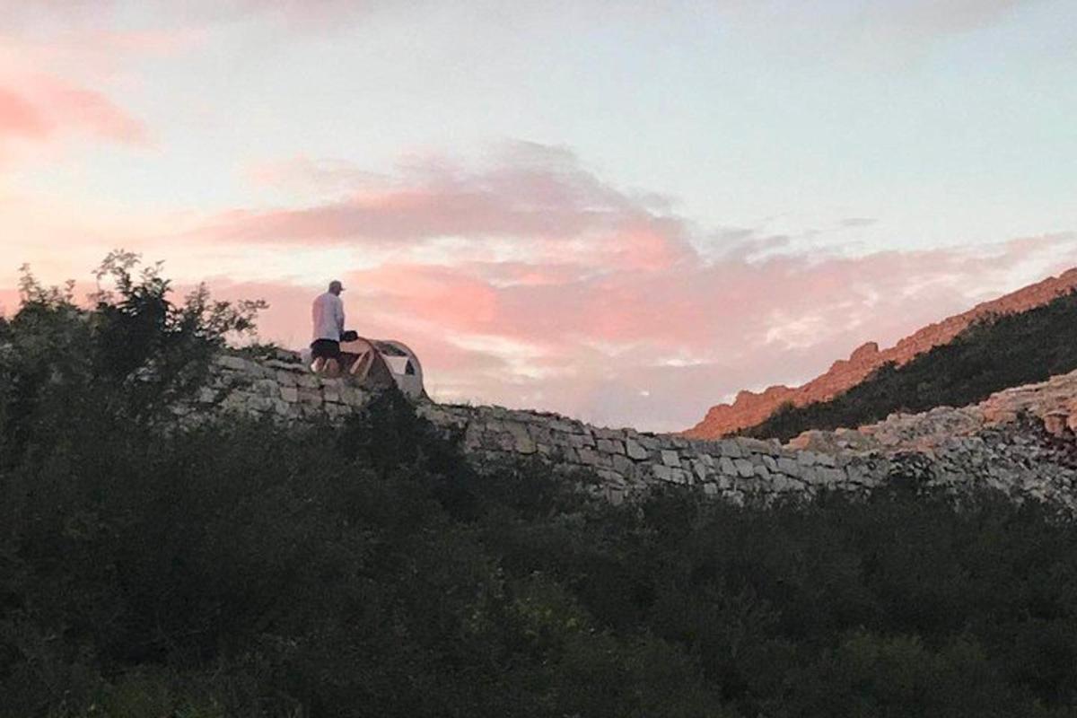 un uomo è seduto su un muro di pietra
