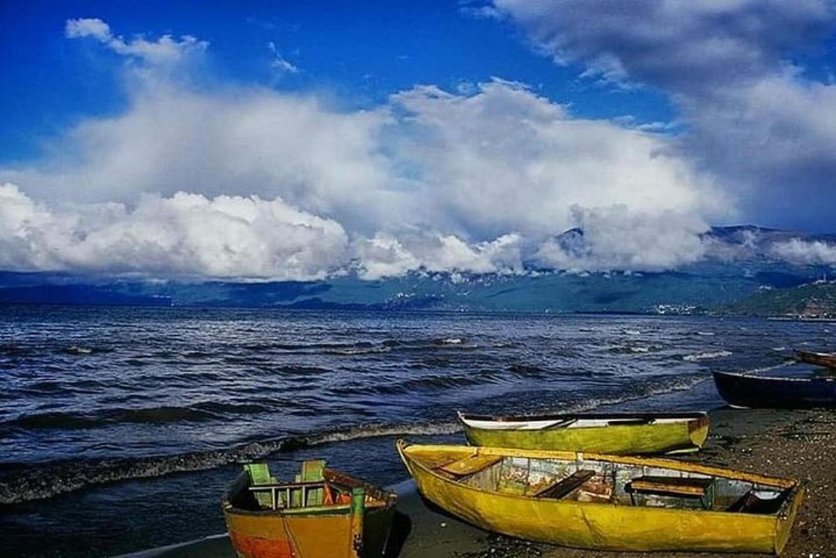 tres barcos en la orilla de un cuerpo de agua