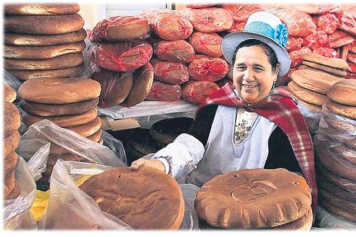 seorang wanita berdiri di hadapan kedai roti dengan roti