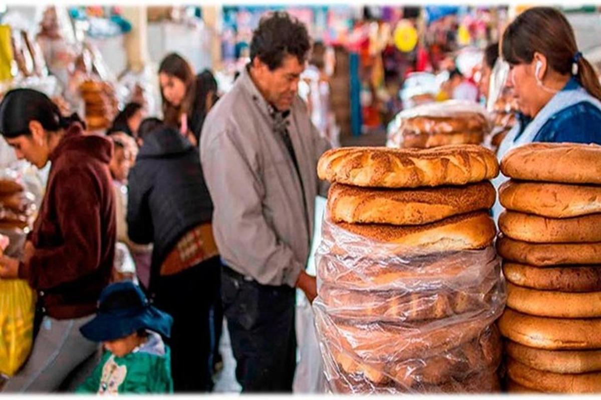 sekumpulan orang berdiri di sekeliling pasar dengan roti