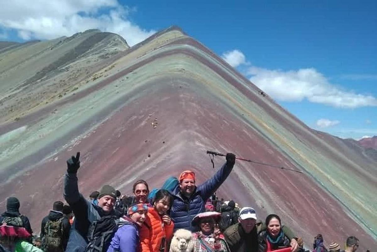 un grup de oameni care stau în fața unui munte