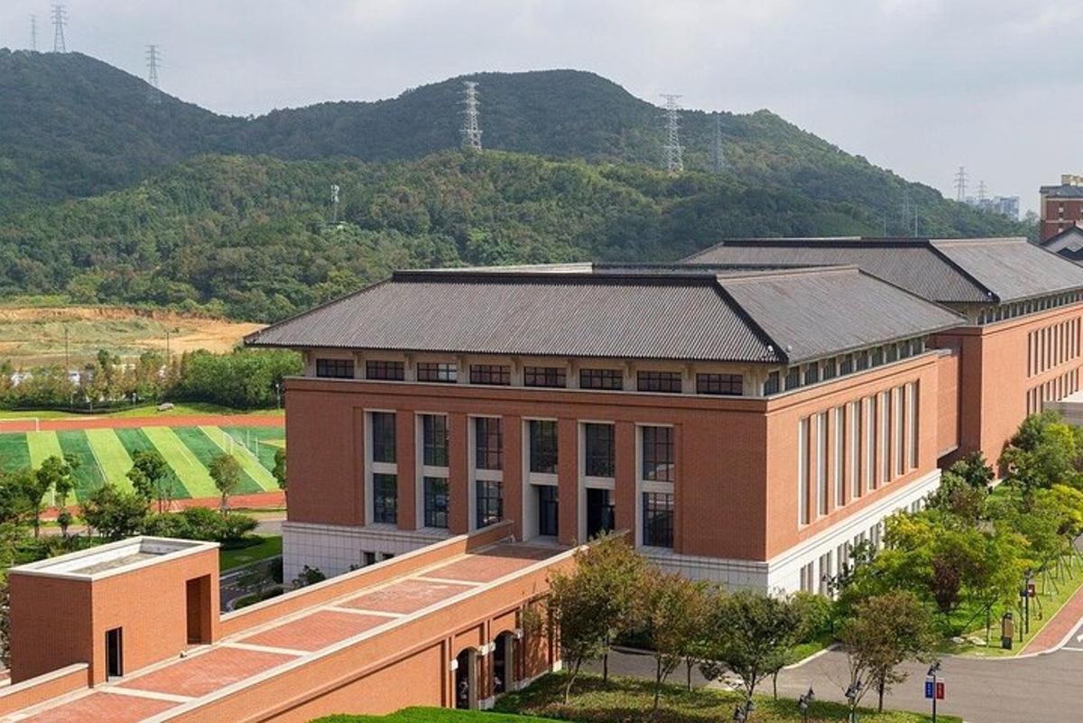 a large brick building with a mountain in the background