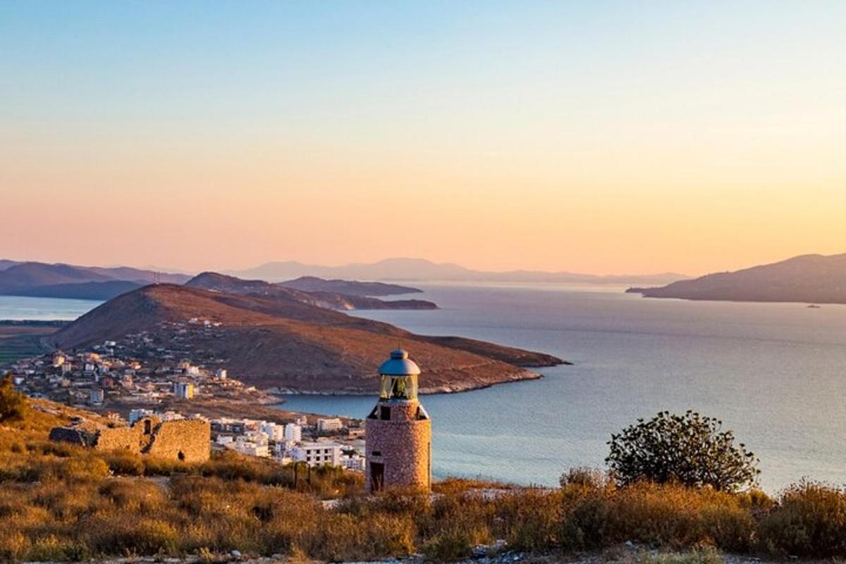 a lighthouse on a hill next to the ocean