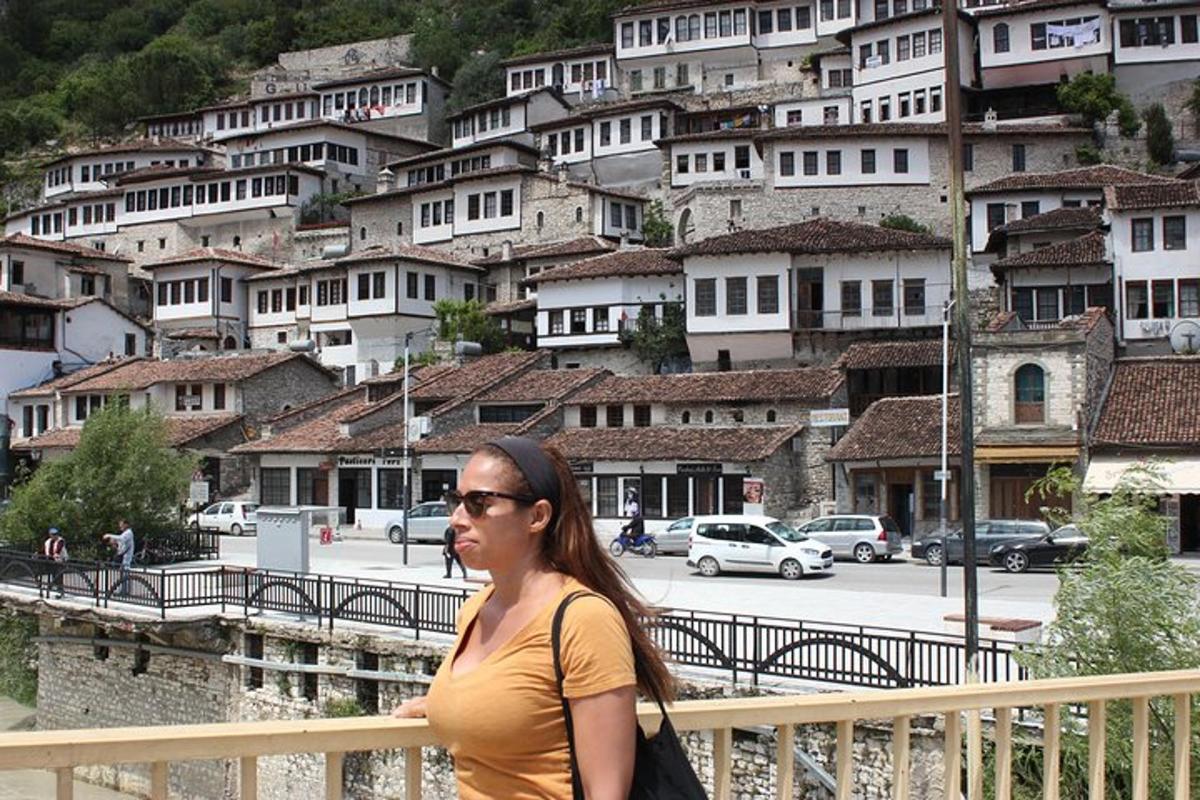 una donna in piedi su un ponte di fronte a una montagna