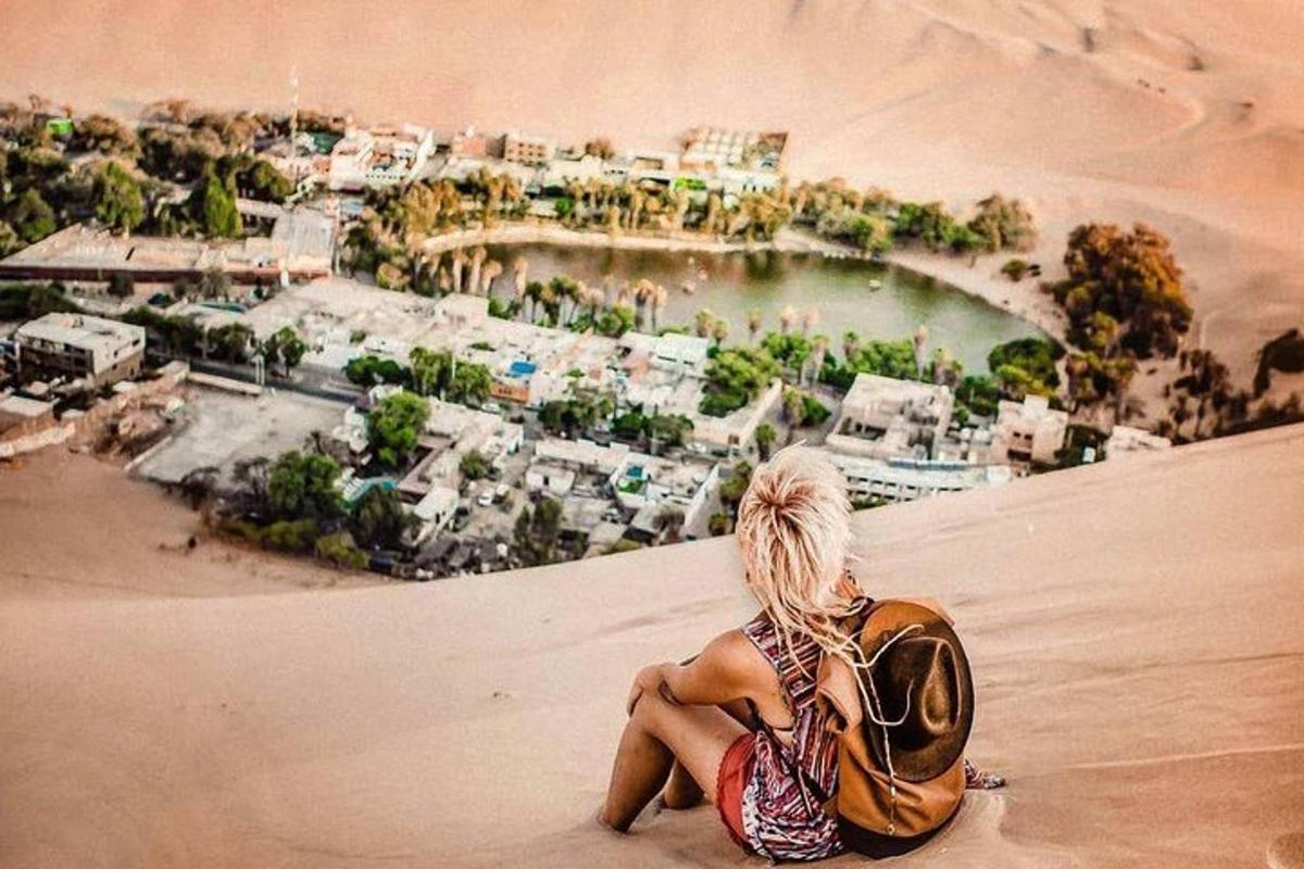una mujer sentada en la arena en el desierto
