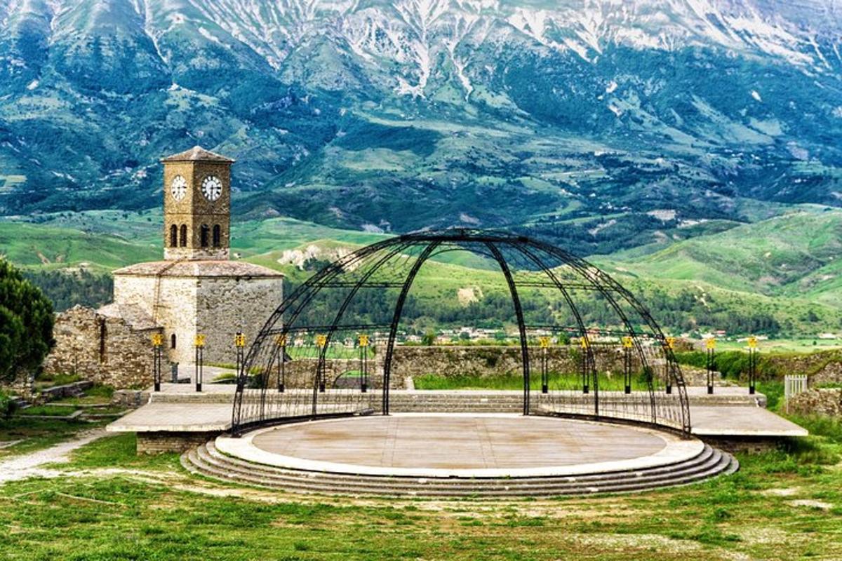 un edificio con una torre dell'orologio di fronte a una montagna