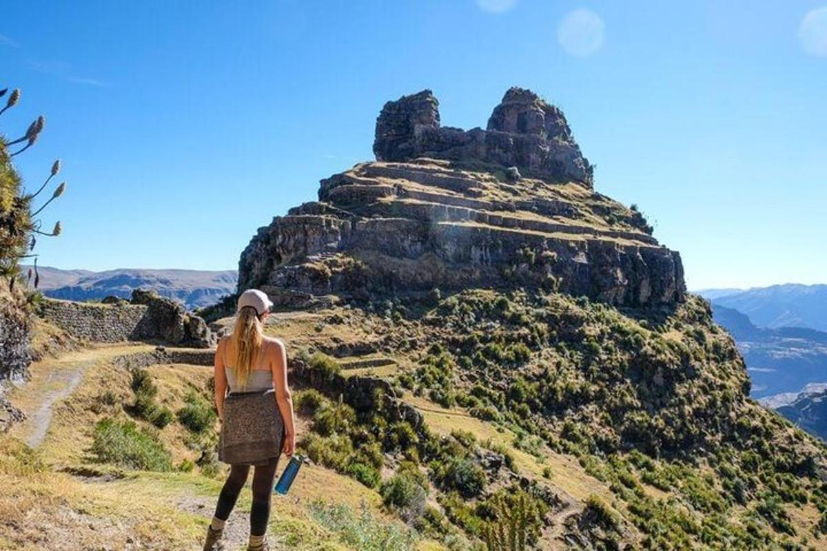 uma mulher em pé no topo de uma montanha