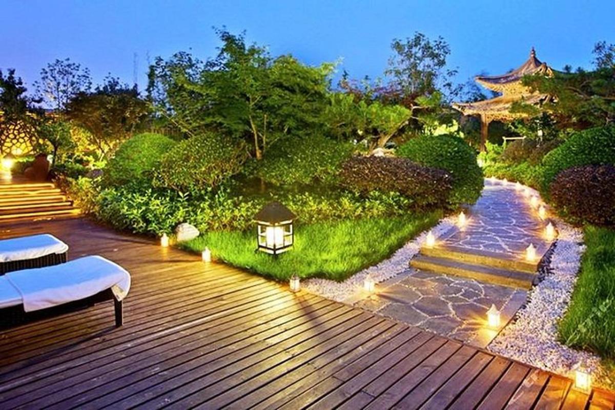 a wooden deck with a bench and lights on it