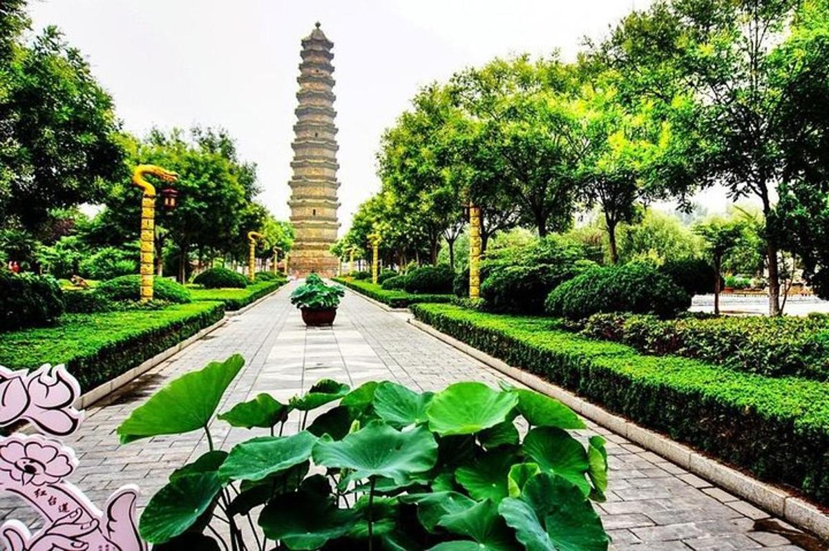 um jardim com uma torre no meio de um parque