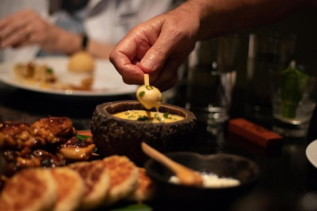 egy személy, aki kanalat tart egy tál ételben