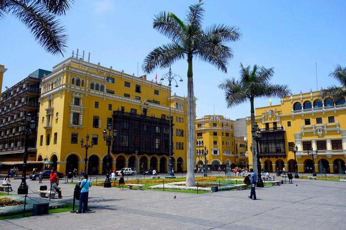 un edificio giallo con palme di fronte