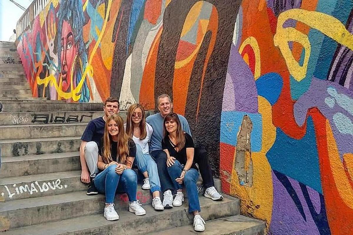 un grup de oameni așezați pe trepte în fața unui perete