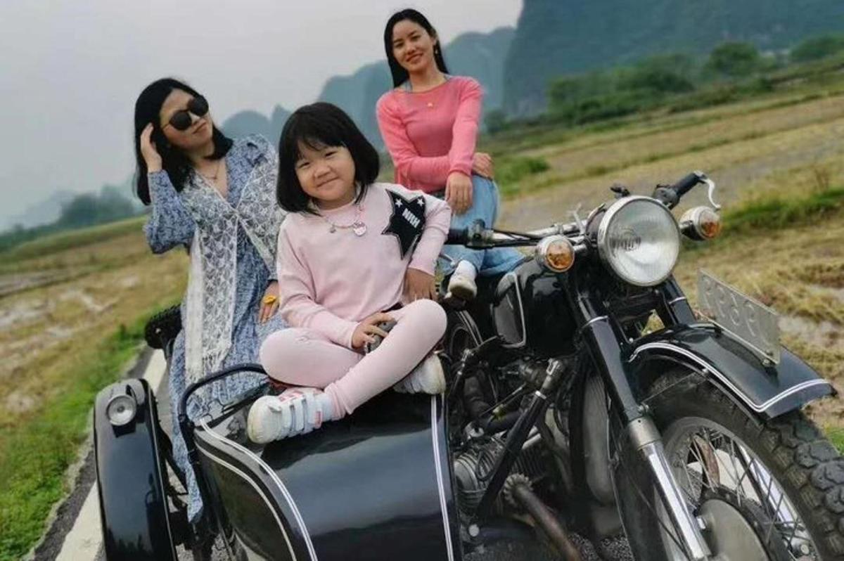 três mulheres sentadas em uma motocicleta com sidecar