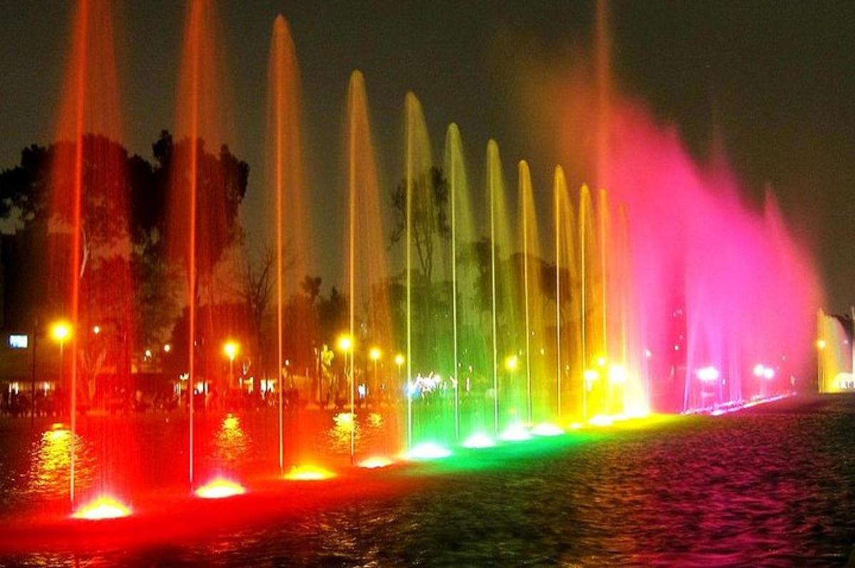 a water fountain with colorful lights in a city