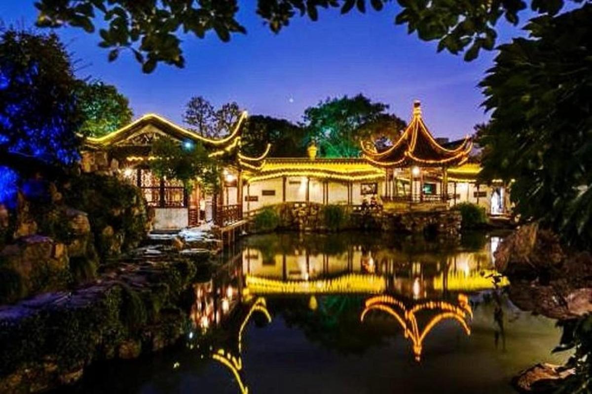 a building with a reflection in the water at night