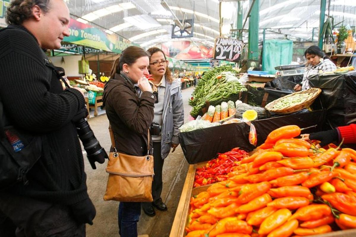 un gruppo di persone in piedi in un mercato con le carote
