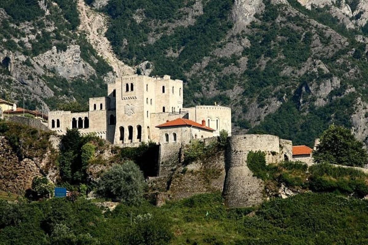 un edificio in cima a una collina con una montagna