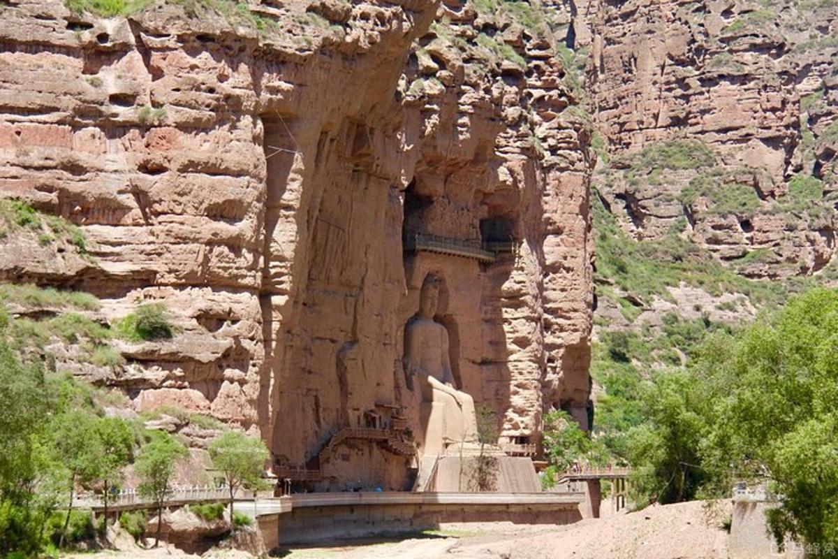 a statue in the side of a rocky mountain